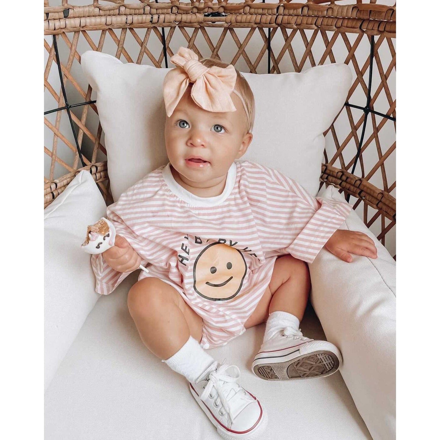 Baby girl in pink bubble romper with smiley face on sweatshirt
