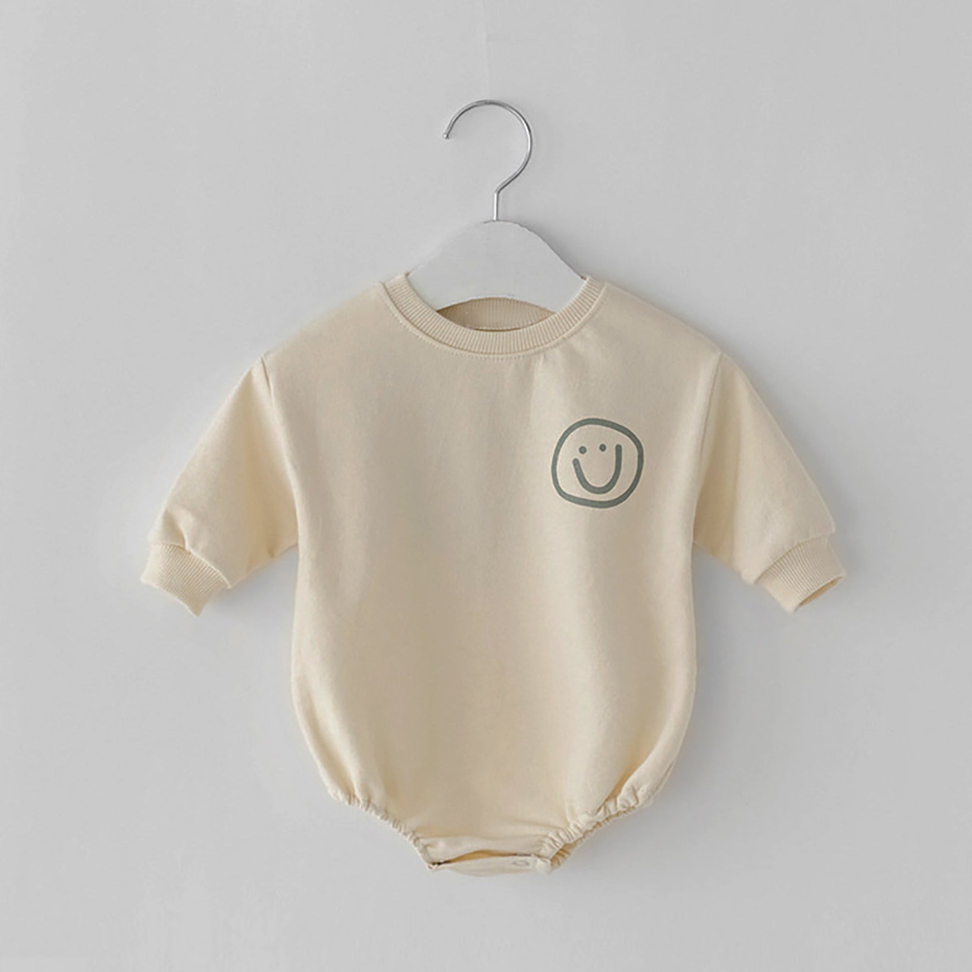 Beige Baby Romper with green smiley face on corner 
